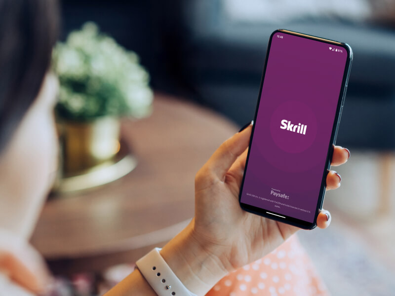person opening the Skrill app on their phone
