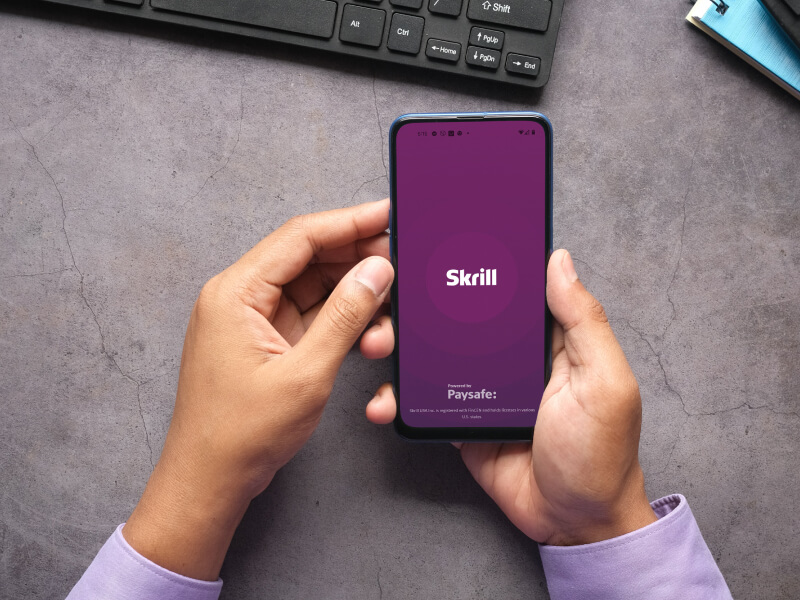 Person opening the Skrill mobile app on their phone