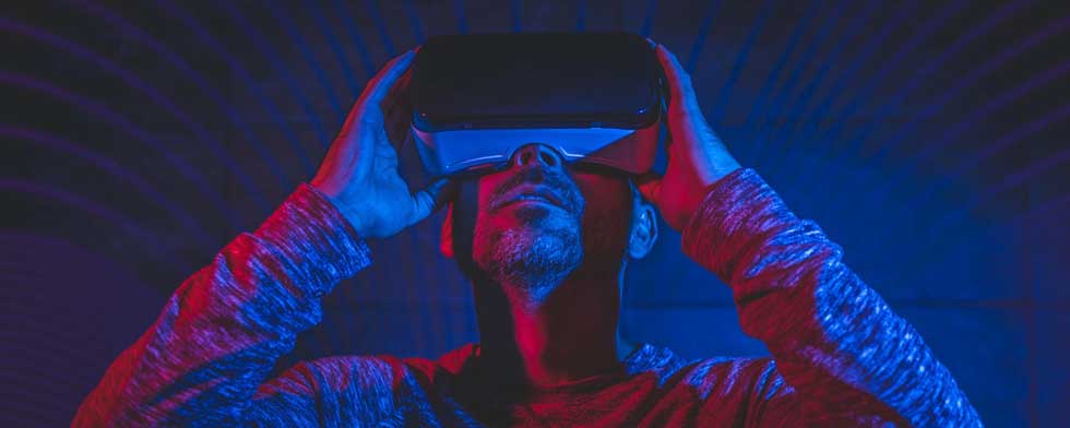 A man with beard wearing VR glasses