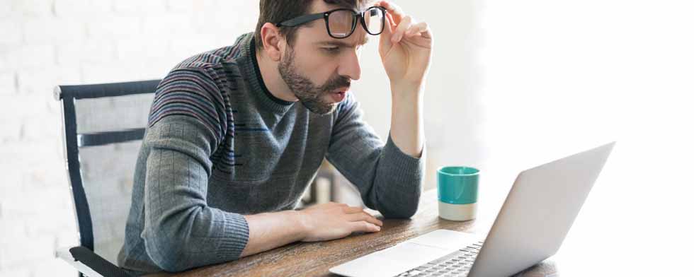 man looking surprisingly at his laptop