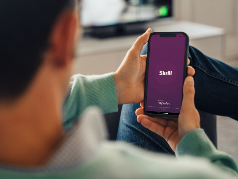 Person opening the Skrill mobile app on their phone