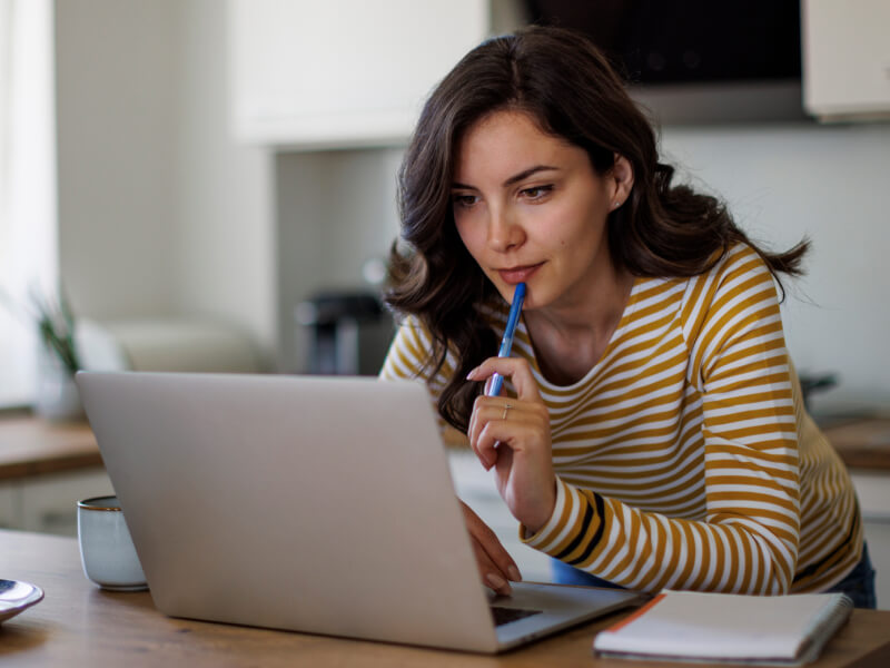 a woman looking at her laptop as though researching gold