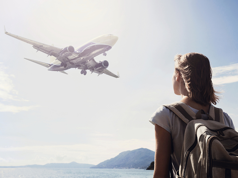 woman looking at a flying plane