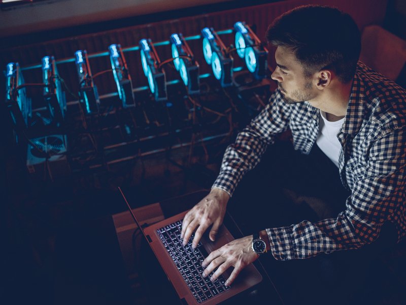 One man, sitting in his office next to the mining rig, using his computer to mine bitcoin.