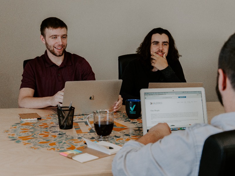 3 men working in a room with laptops