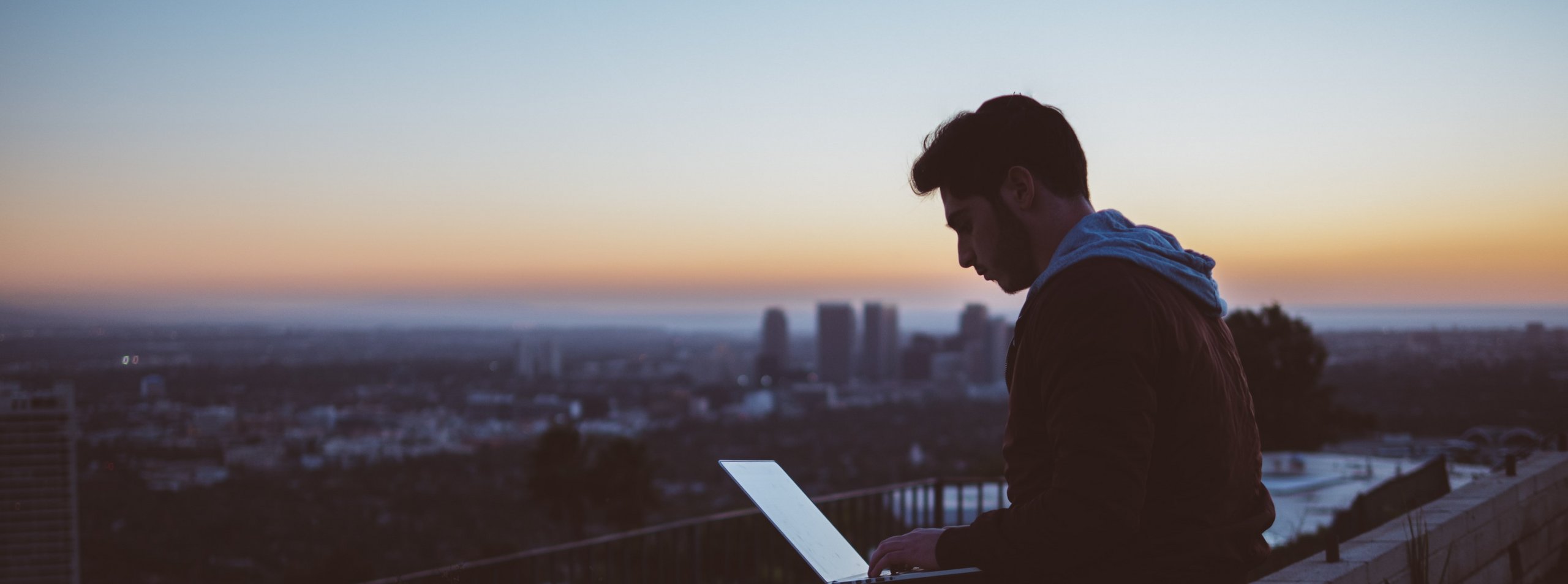Trader with a laptop on a sunset