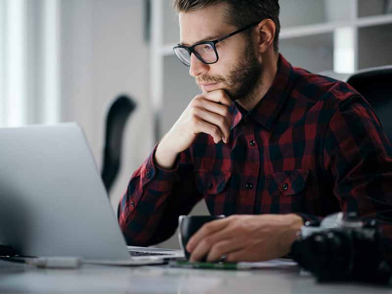 man reading on a laptop