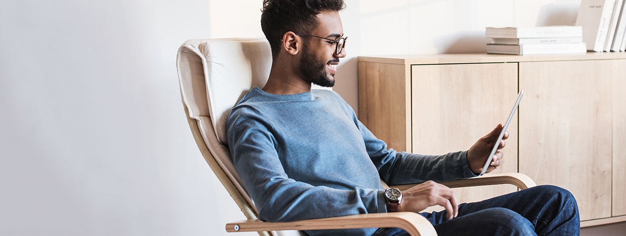 man sitting on a couch typing on his laptop