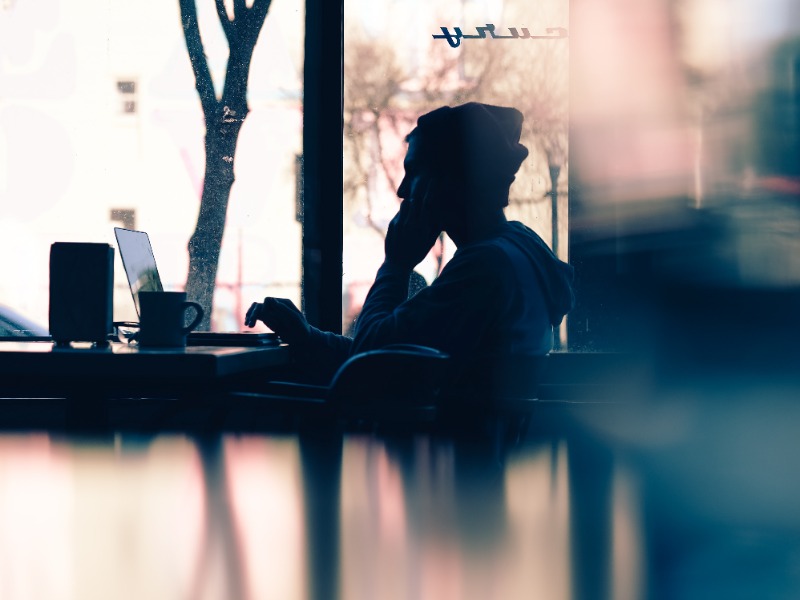 people sitting on a table with laptops and working