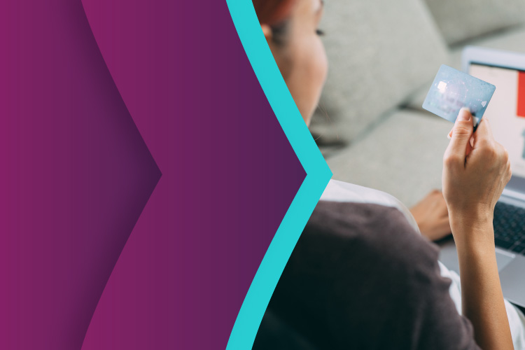 Lady using her card for online payment on her PC, branded with Skrill purple and teal arrows